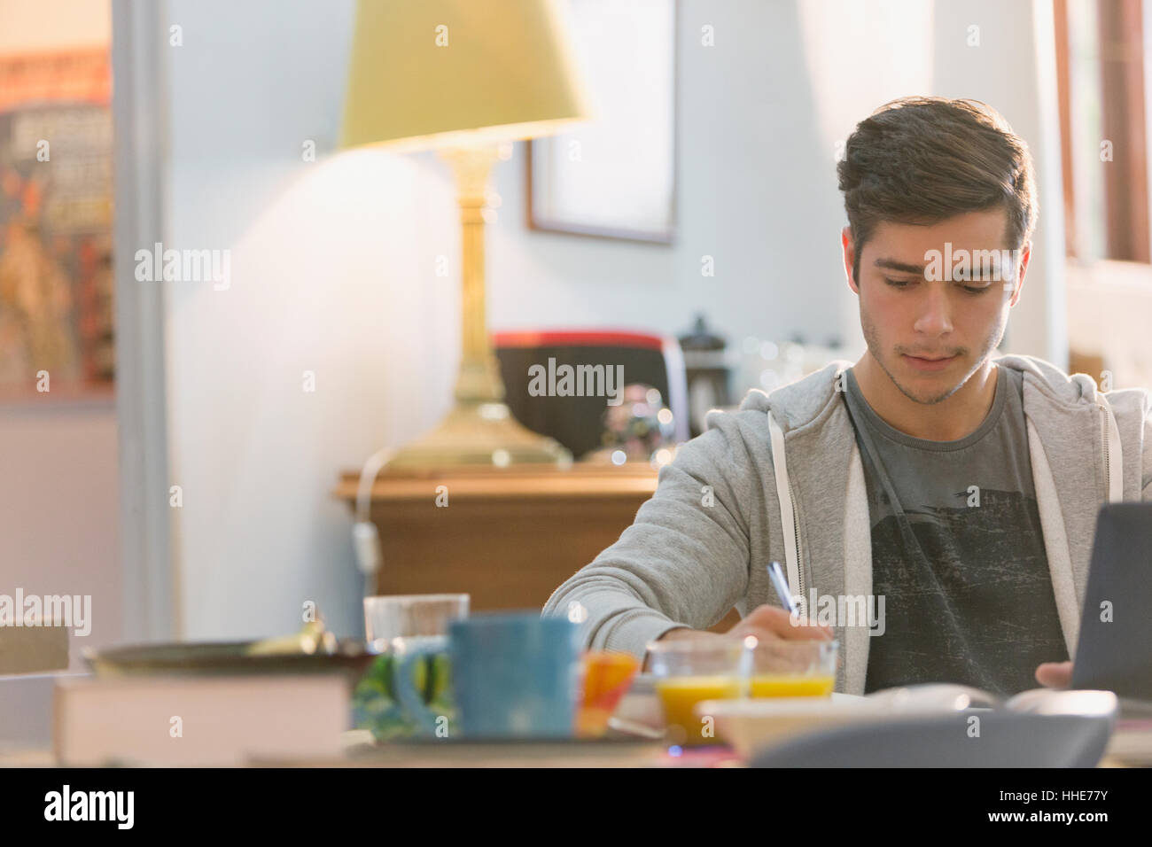 Young man college student studying at breakfast table Stock Photo