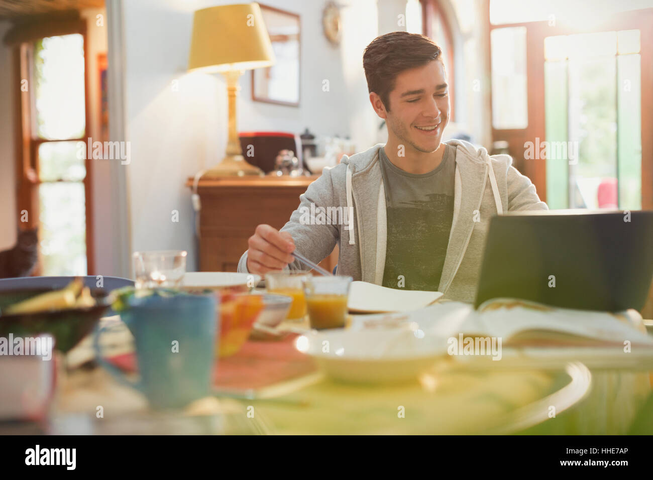 Young man college student using laptop studying at breakfast Stock Photo