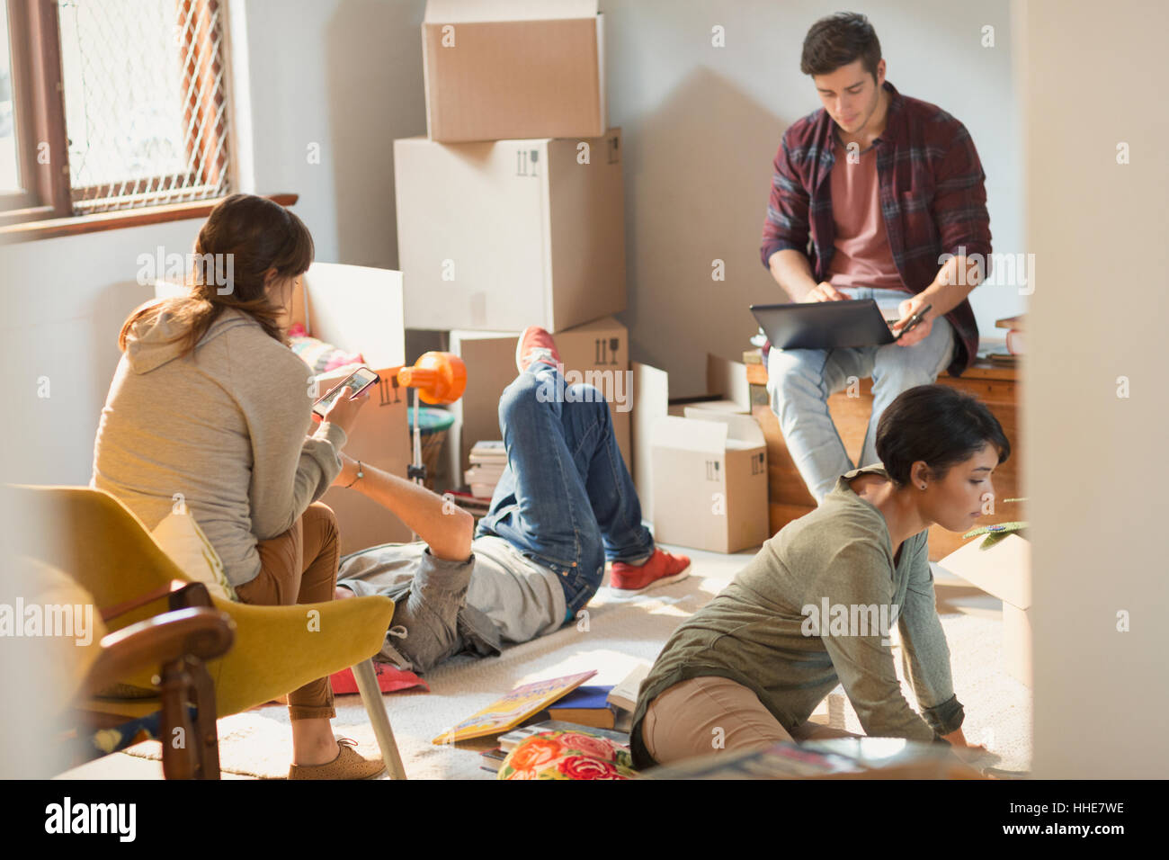 Young friends roommates moving in unpacking boxes in apartment Stock Photo