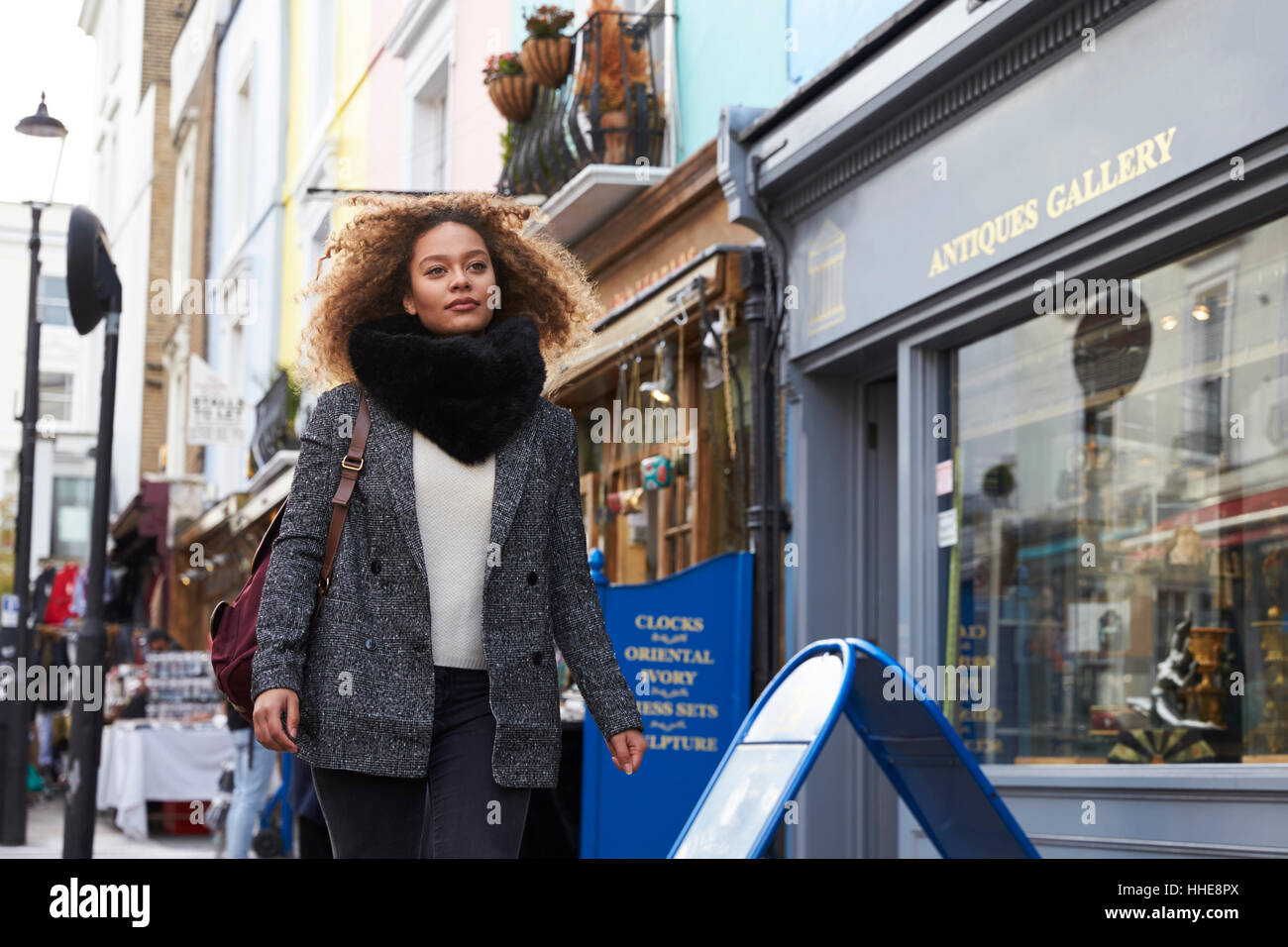 Stylish Young Woman Walking Along Busy City Street Stock Photo - Alamy