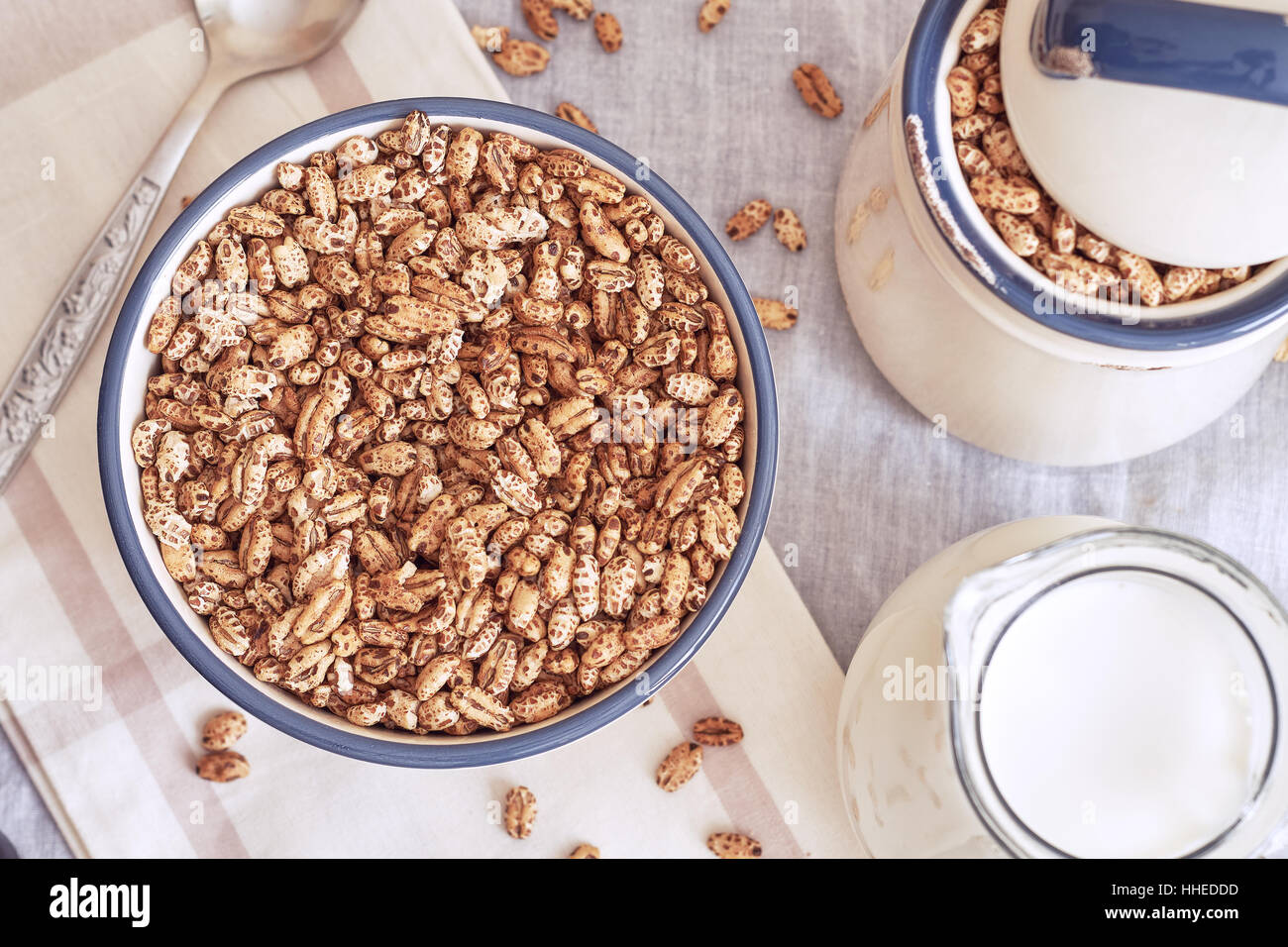 Puffed barley cereal in bowl with pitcher of milk. Top view Stock Photo