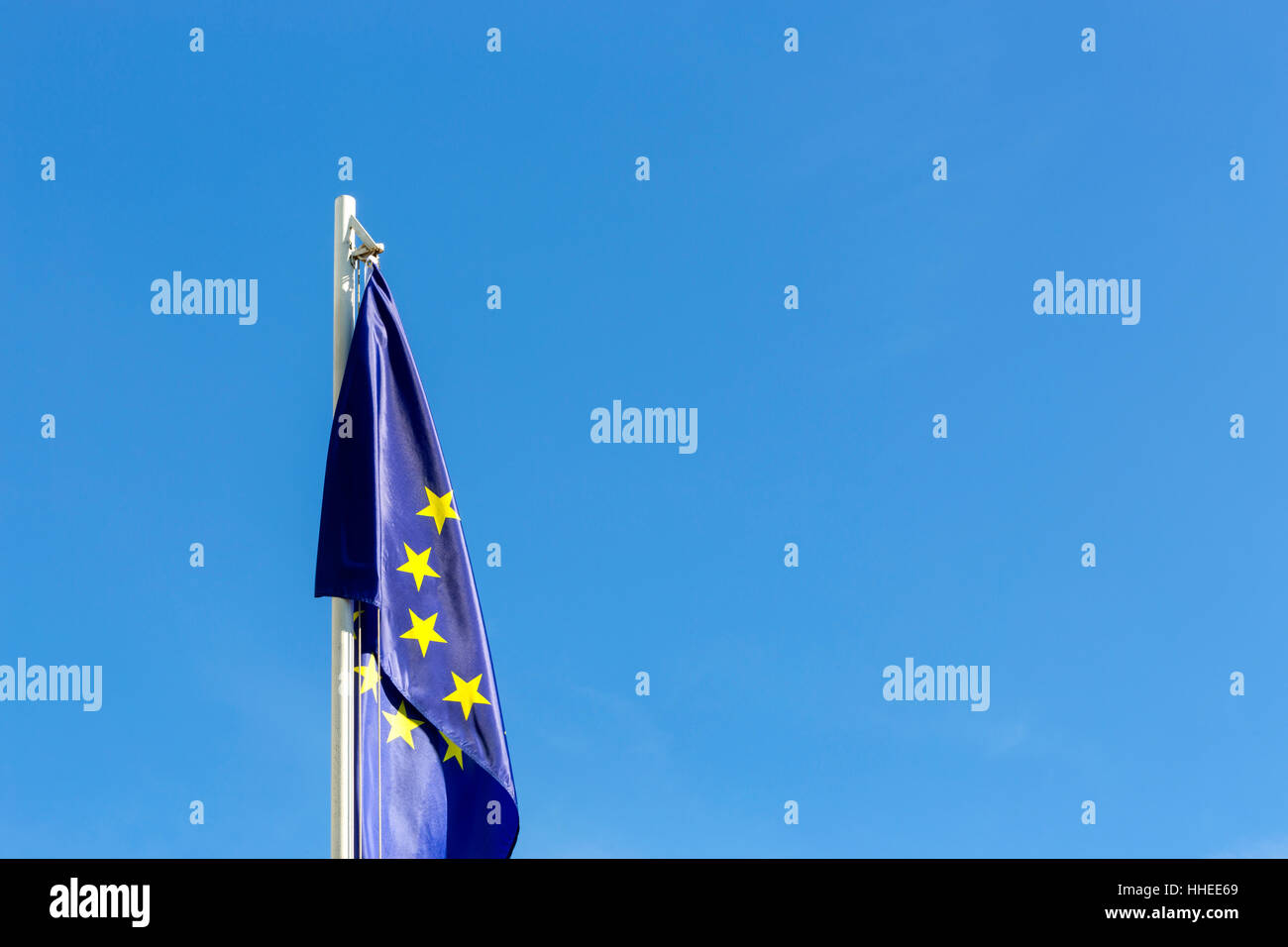 Flag of European Union on a flagpole in front of blue sky Stock Photo
