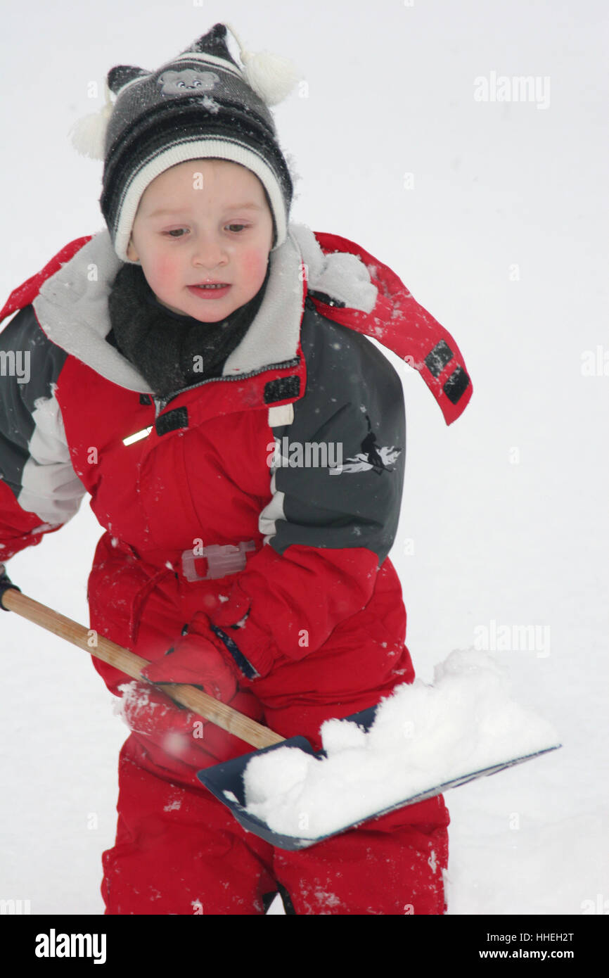 Three-year-old boy shoveling snow Stock Photo