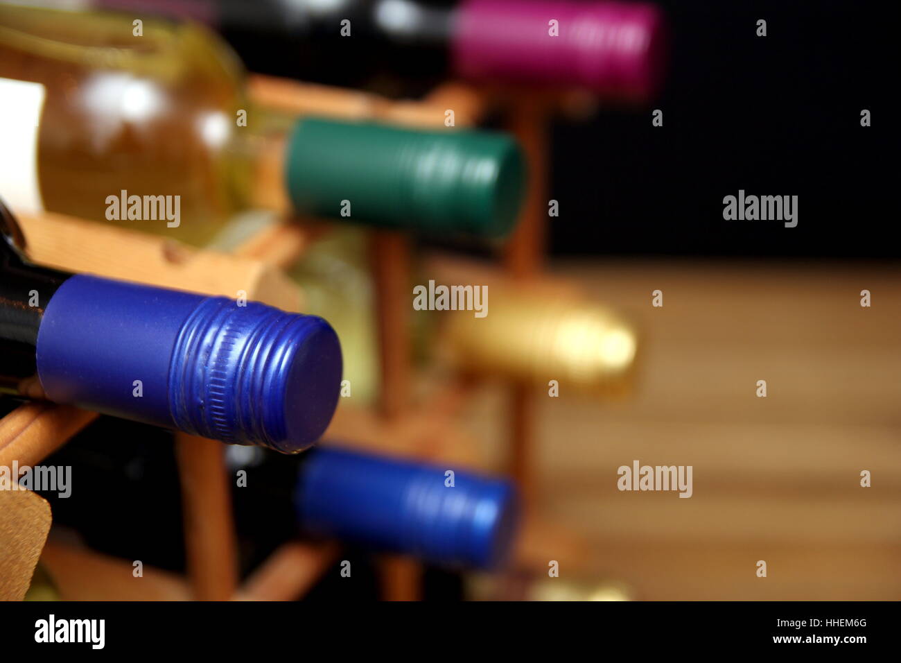 Various red and white wine bottles in a wooden wine rack with space for text Stock Photo
