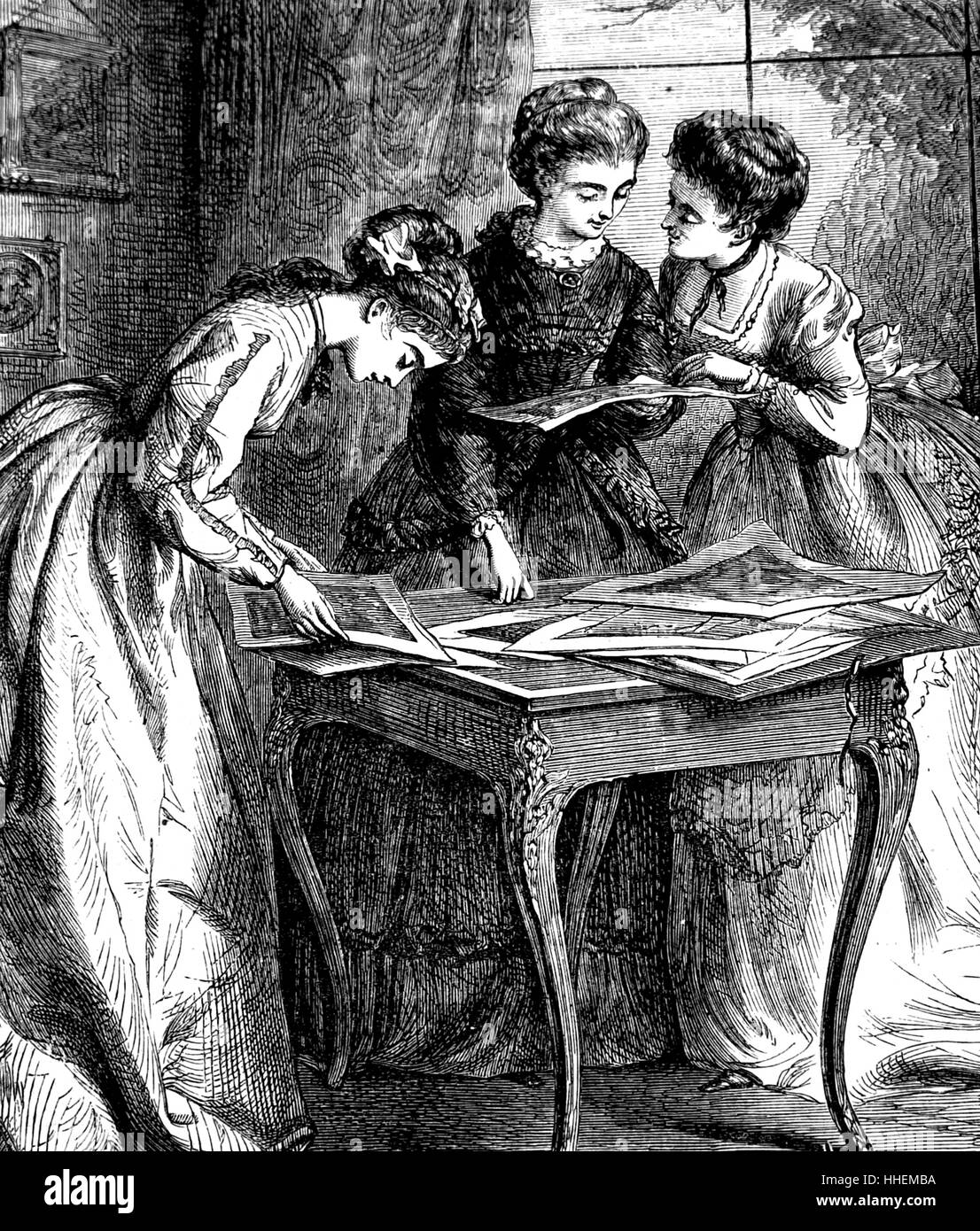 Illustration depicting ladies examining a drawing-room portfolio. Dated 19th Century Stock Photo