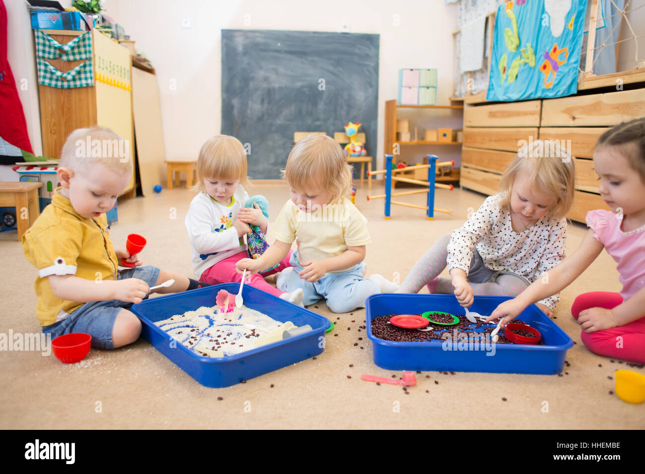 Children improving hands motor skills with rice and beans Stock Photo