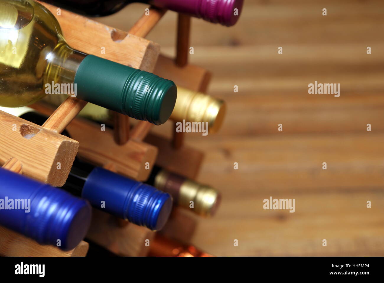 Various red and white wine bottles in a wooden wine rack with space for text Stock Photo