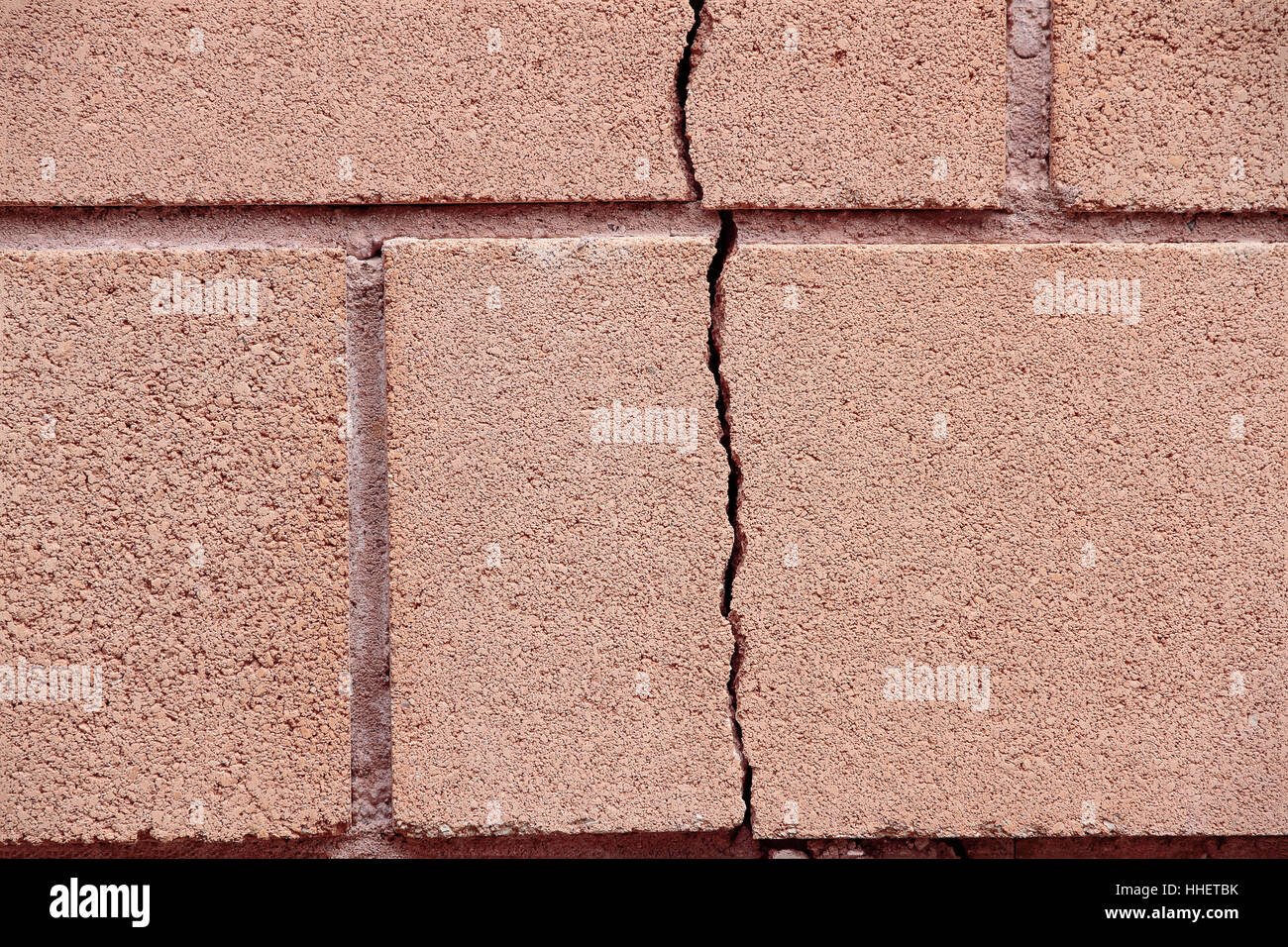 foreground of a vertical crack on a wall of bricks Stock Photo