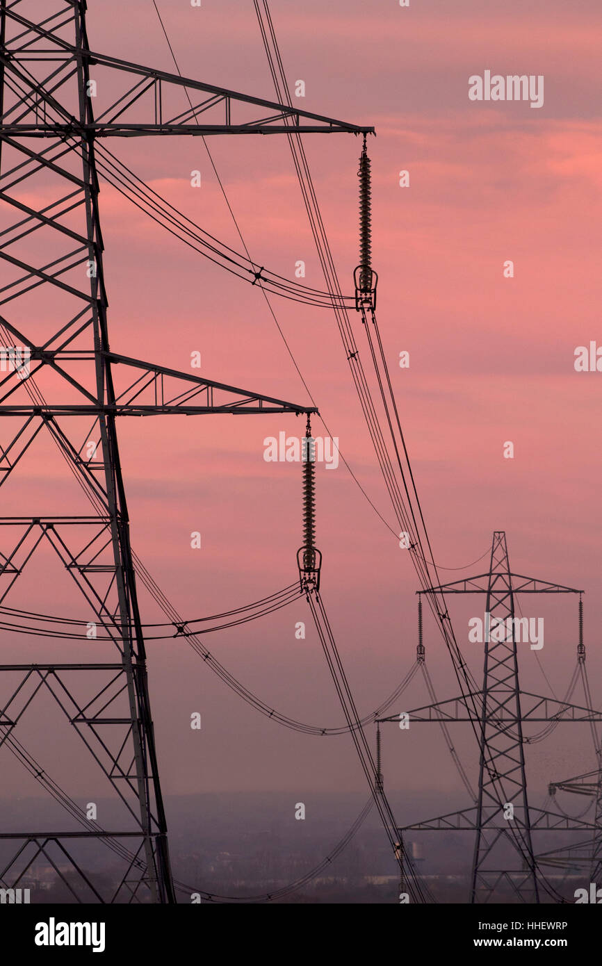 Electricity Pylons silhouetted against evening sky Stock Photo - Alamy