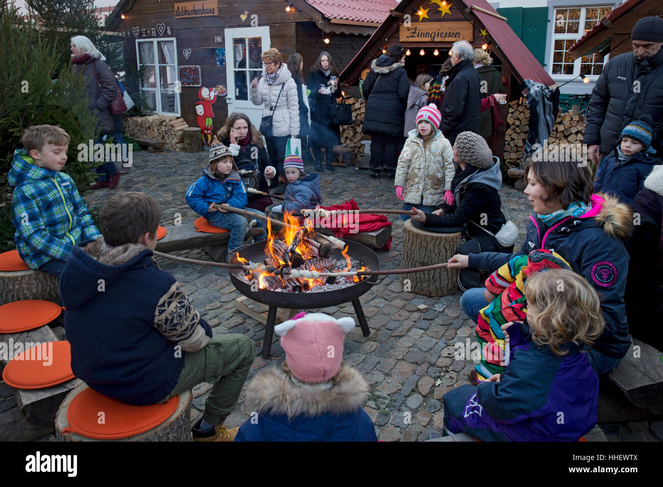 Children around open fire cooking traditional bread at Christmas market,Basel,Switzerland Stock Photo