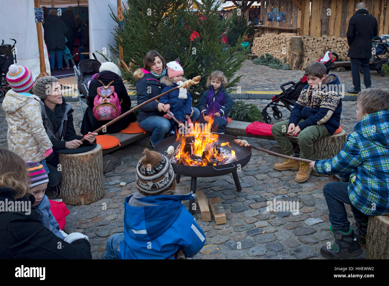 Children around open fire cooking traditional bread at Christmas market,Basel,Switzerland Stock Photo