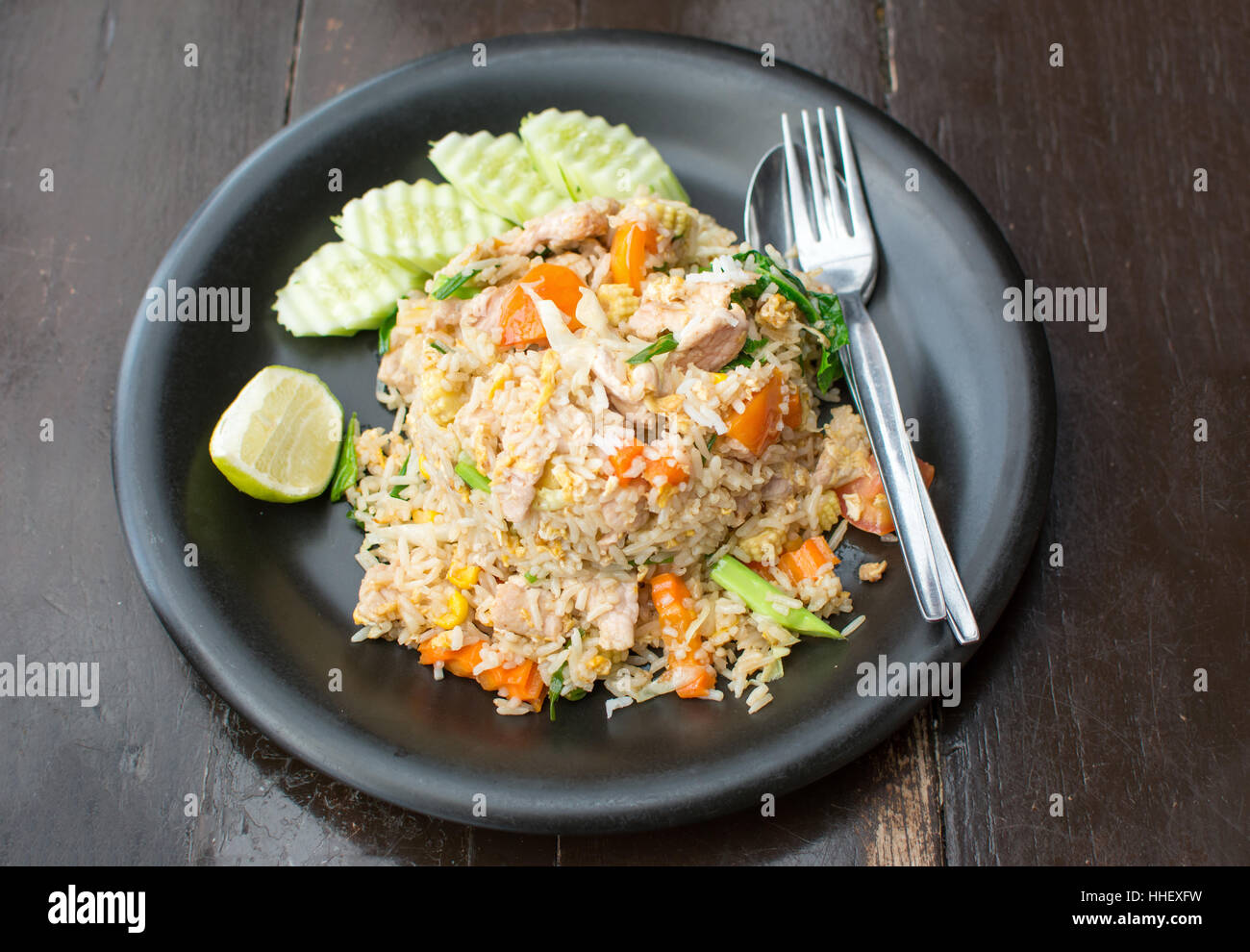Fried rice with meat and vegetables served on a plate Stock Photo
