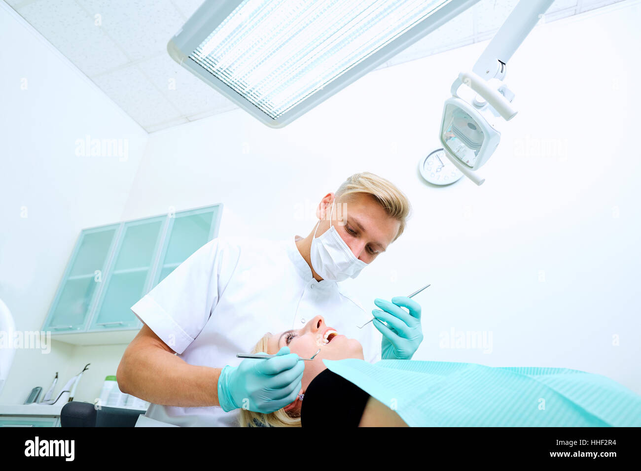 The dentist treats a patient mask in dental office Stock Photo Alamy