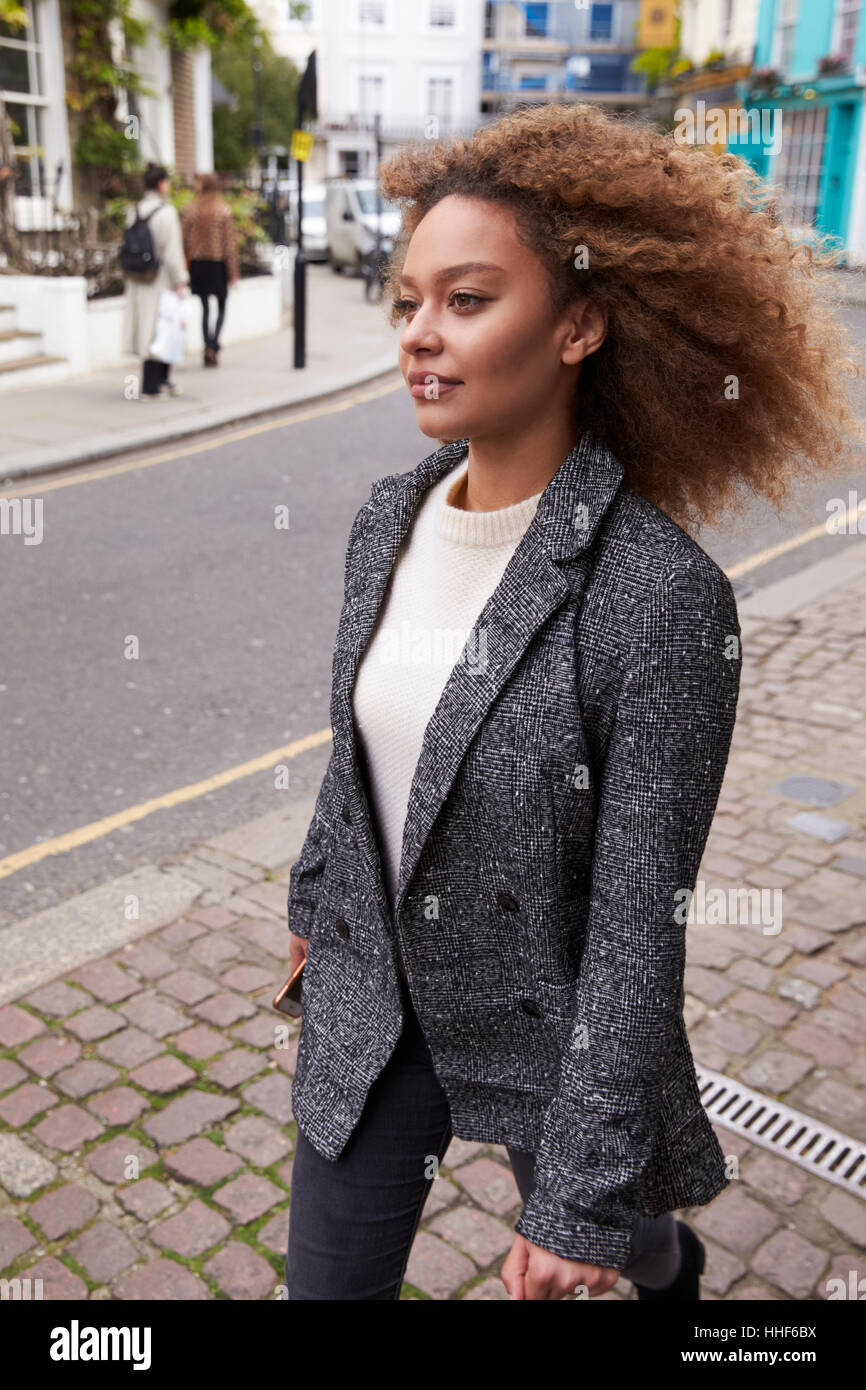 Stylish Young Woman Walking Along Busy City Street Stock Photo - Alamy