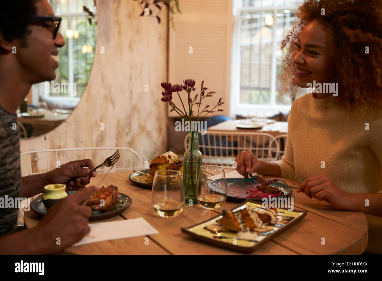 Young Couple Enjoying Meal On Date In Restaurant Stock Photo