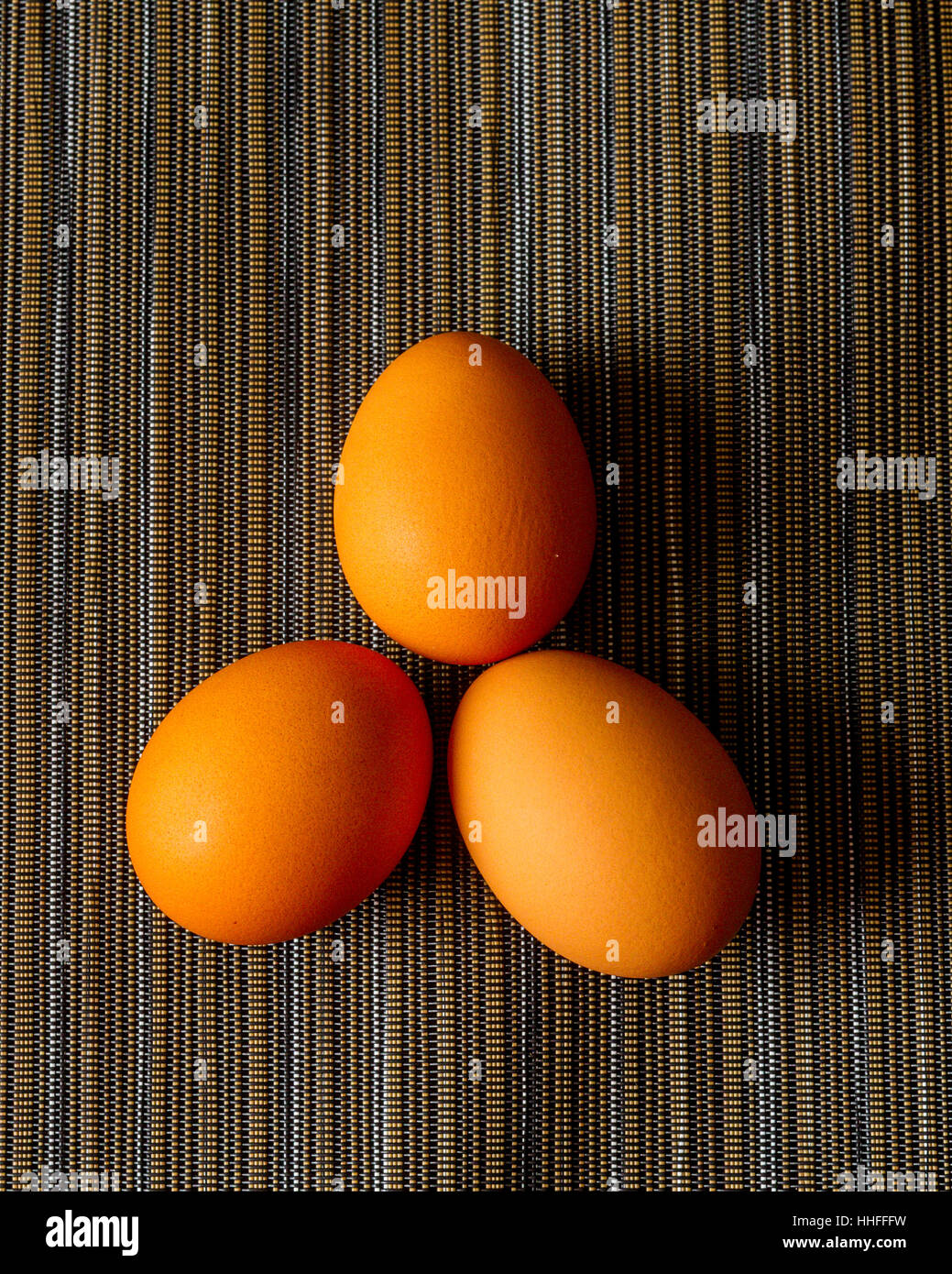 Three Brown organic chicken eggs on a place mat Stock Photo