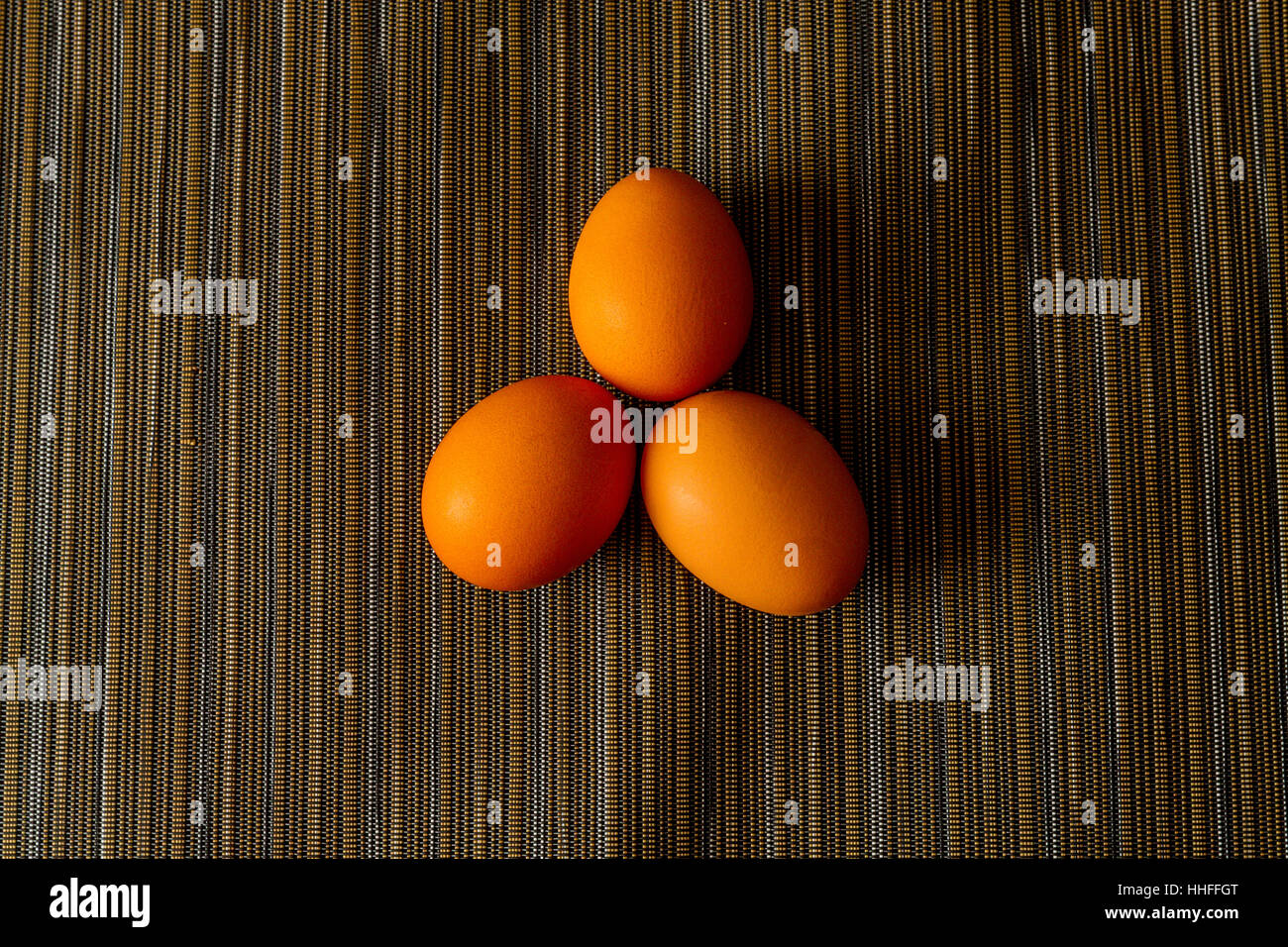 Three Brown organic chicken eggs on a place mat Stock Photo