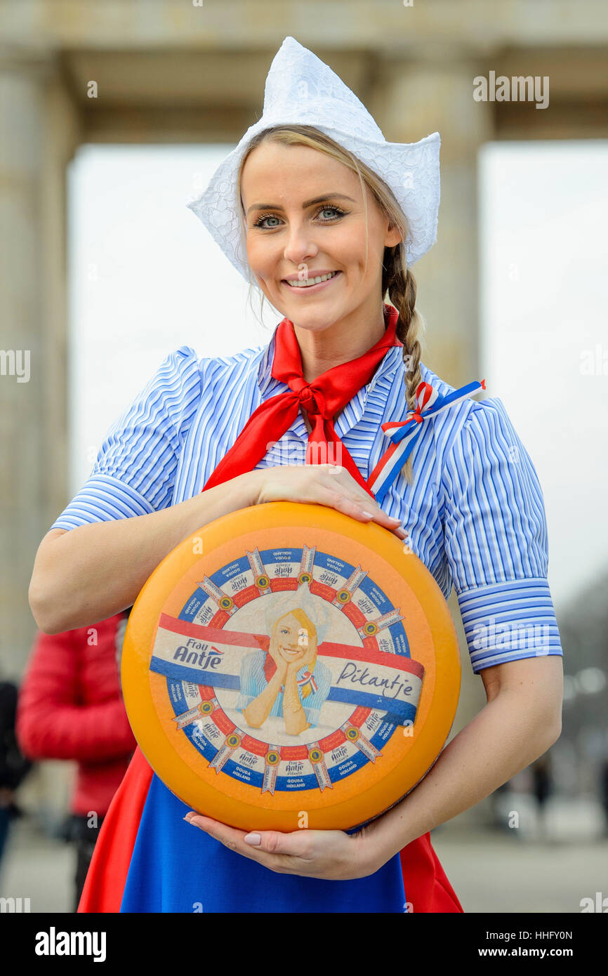 Berlin, Germany. 19th Jan, 2017. The Cheese Queen of the Netherlands, Floor Schothorst, promotes Dutch cheese as 'Frau Antje' in red, white, and blue national costume with a wheel of cheese in front of the Brandenburg Gate in Berlin, Germany, 19 January 2017. The International Green Week is open to visitors from 20 to 29 January 2017. Photo: Gregor Fischer/dpa/Alamy Live News Stock Photo