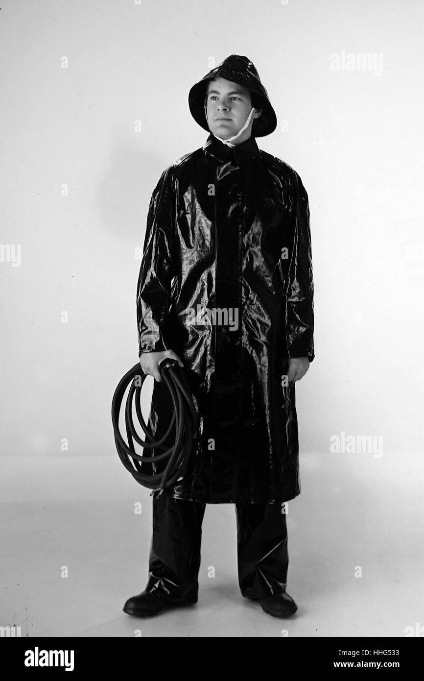 Used extensively by the Admiralty, G.P.O, Ministry of Supply, many of the nationalised industries and large building contractors, the P.V.C Waterproof suit by Northide Ltd. Comprising a long coat, trousers and sou'wester, is of value to all concerns employing outdoor workers. These garments are made from tough rayon fabric, impregnated and proofed with P.V.C They are flexible, resistant to abrasion, oils and greases, and due to their lightness in weight, they are extremely confrontable . All main seams are stitched and electronically welded for complete waterproofing in the most severe weather Stock Photo