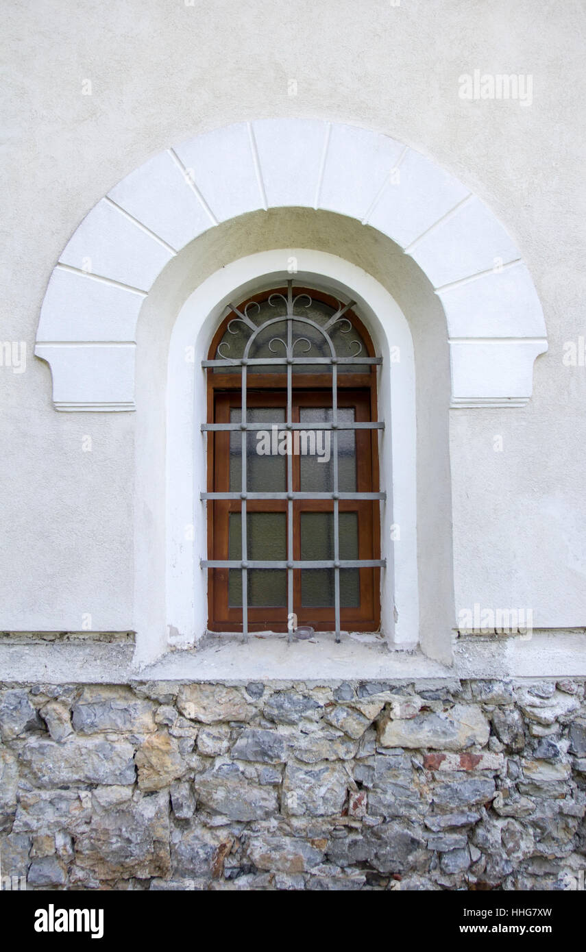 Window with iron bars on the old church. Stock Photo