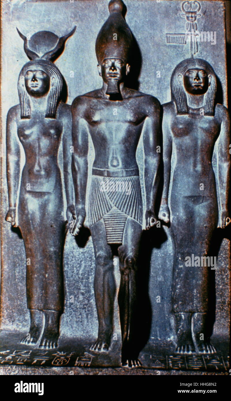 Menkaura flanked by the goddess Hathor (left) and a nome goddess Bat (right). Greywacke statue (Egyptian Museum, Cairo). Menkaure was an ancient Egyptian king (pharaoh) of the 4th dynasty during the Old Kingdom. circa 2500 BC Stock Photo