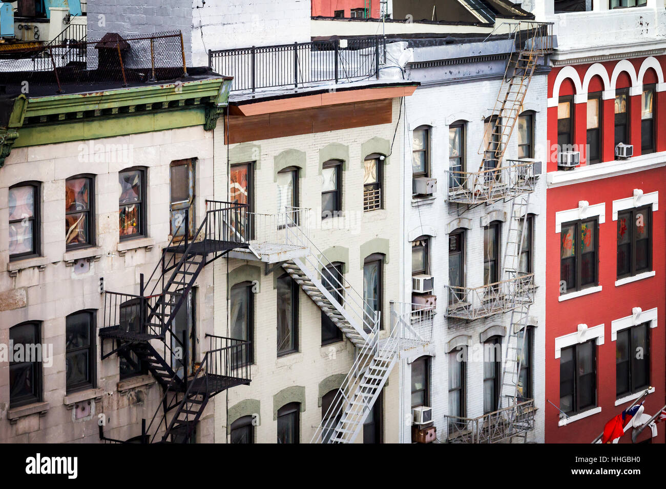 New York City view of historic buildings with windows, rooftops and fire escapes along Bowery street in Chinatown Manhattan Stock Photo