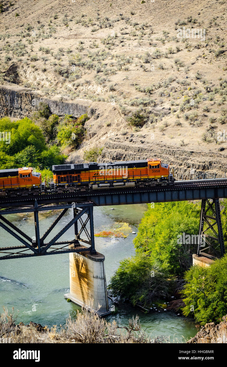 A BNSF train crosses a bridge over the Deschutes River in Eastern Oregon Stock Photo