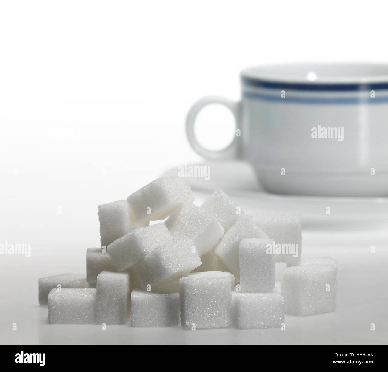 Studio photography of a lump sugar pile in front of a porcelain  coffee cup Stock Photo