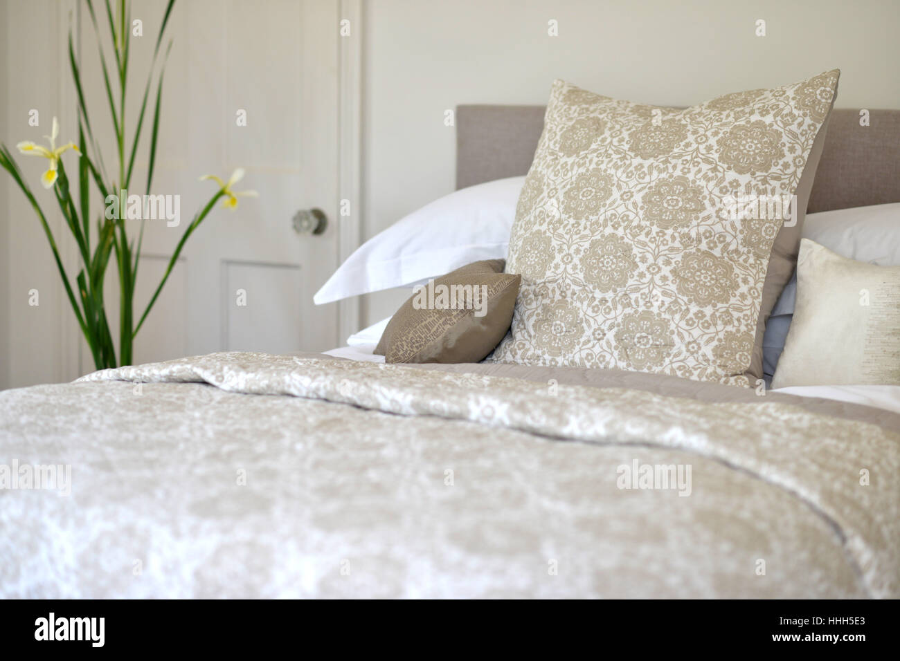 Bed in bedroom setting with luxury bedspread Stock Photo