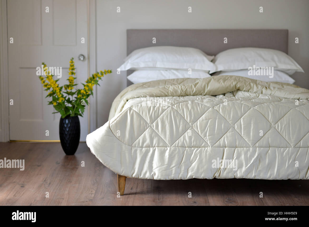 Bed in bedroom setting with luxury bedspread Stock Photo
