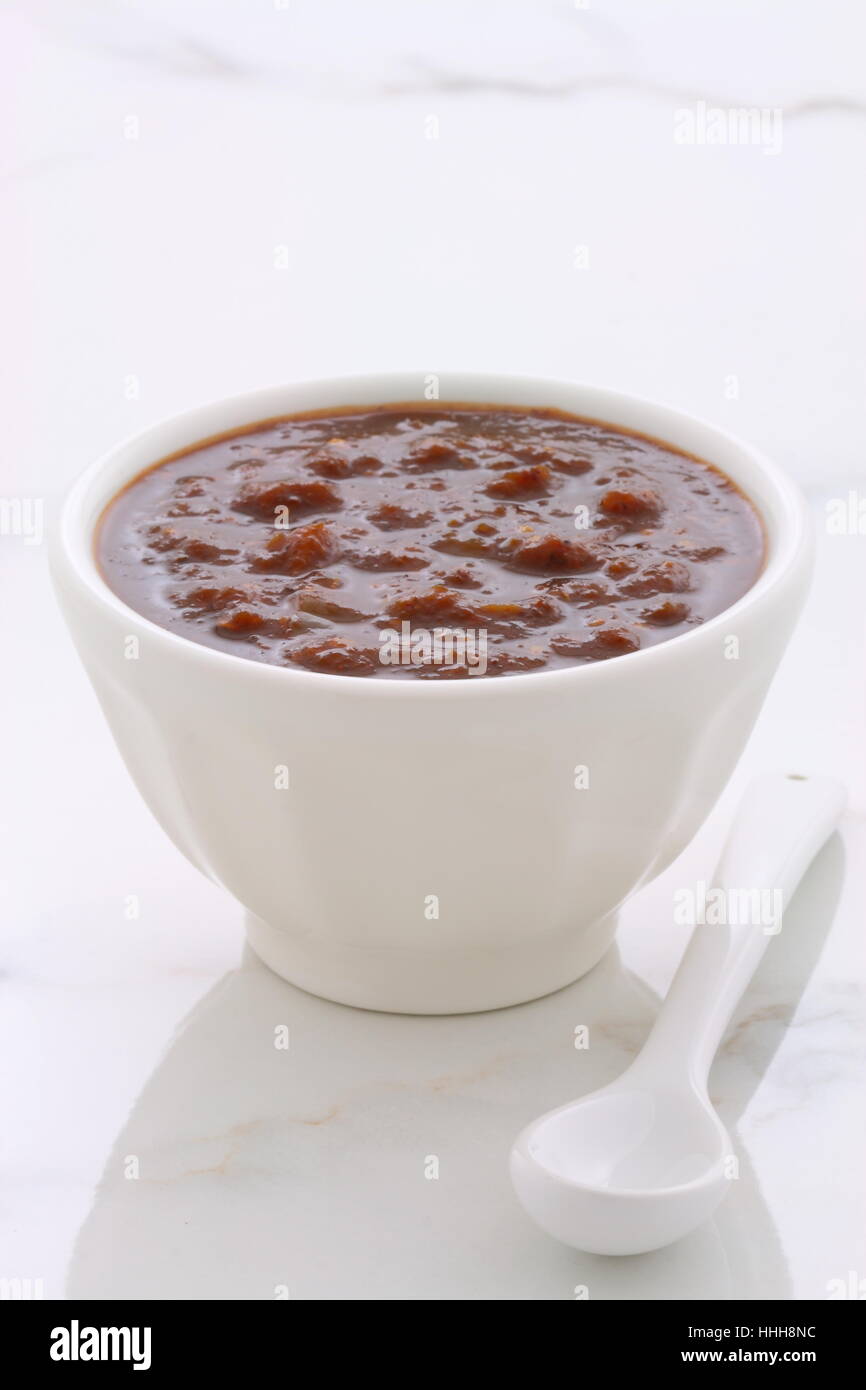 Artisan mexican chipotle sauce on vintage carrara marble table, with a delicious smoky flavor perfect for all your Mexican, tex-mex recipes and sides. Stock Photo
