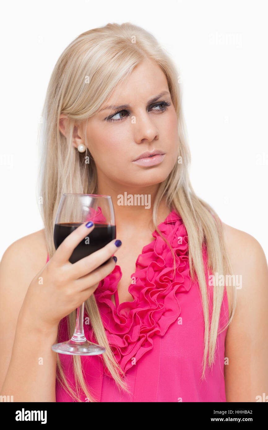 Blonde holding a glass of red wine against white background Stock Photo ...