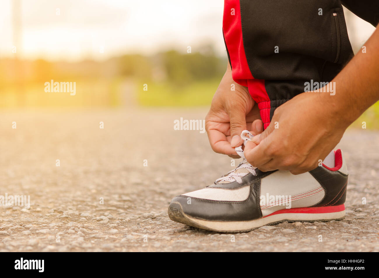 Man  tying shoes at roadside.Or sport man tying shoes. Stock Photo