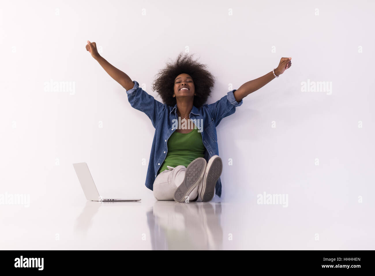 Portrait of happy young african american woman sitting on floor with ...