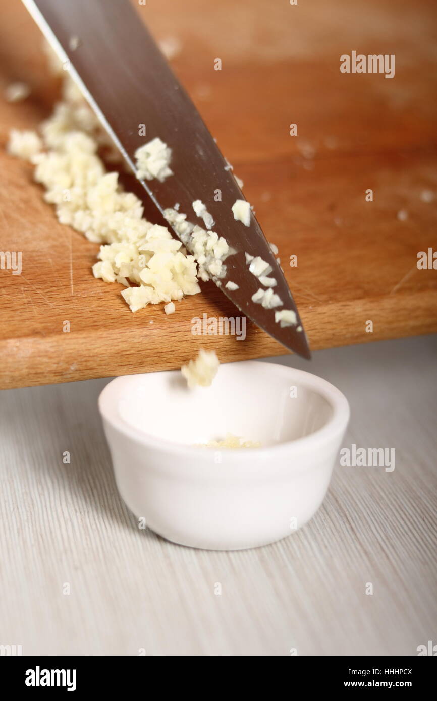 Adding minced garlic into bowl. Making Potato and Leek Filo Pie. Series. Stock Photo