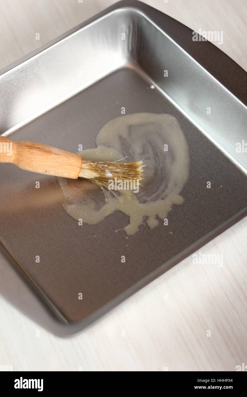 Brushing baking pan with butter. Making Potato and Leek Filo Pie. Series. Stock Photo