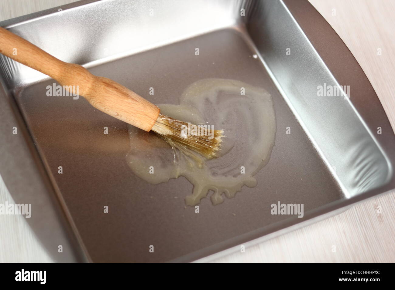 Brushing baking pan with butter. Making Potato and Leek Filo Pie. Series. Stock Photo