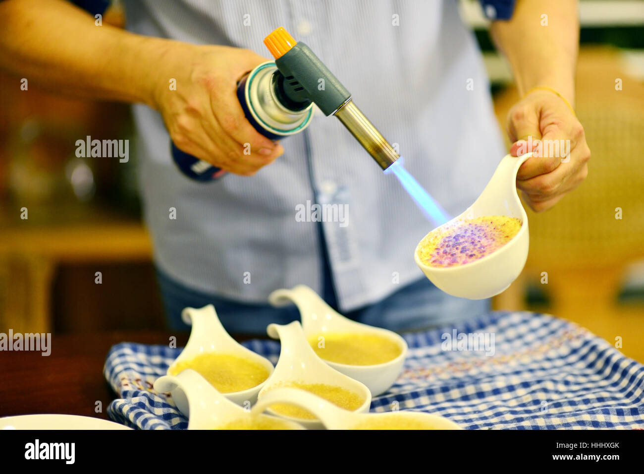 Pastry Chef caramelizing a creme brulee using a torch Stock Photo Alamy