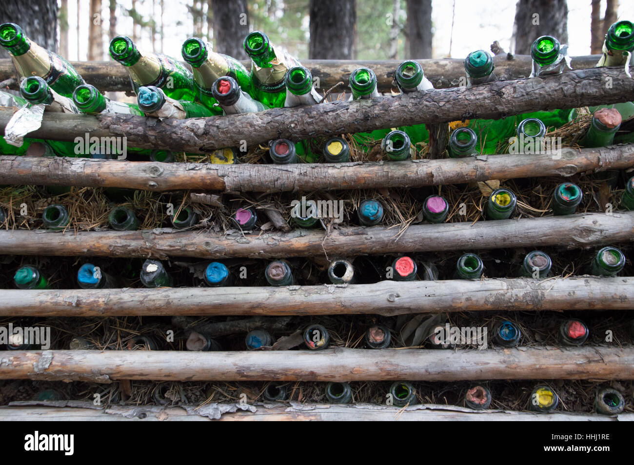 Close up of empty green champagne bottles with colorful stoppers tucked