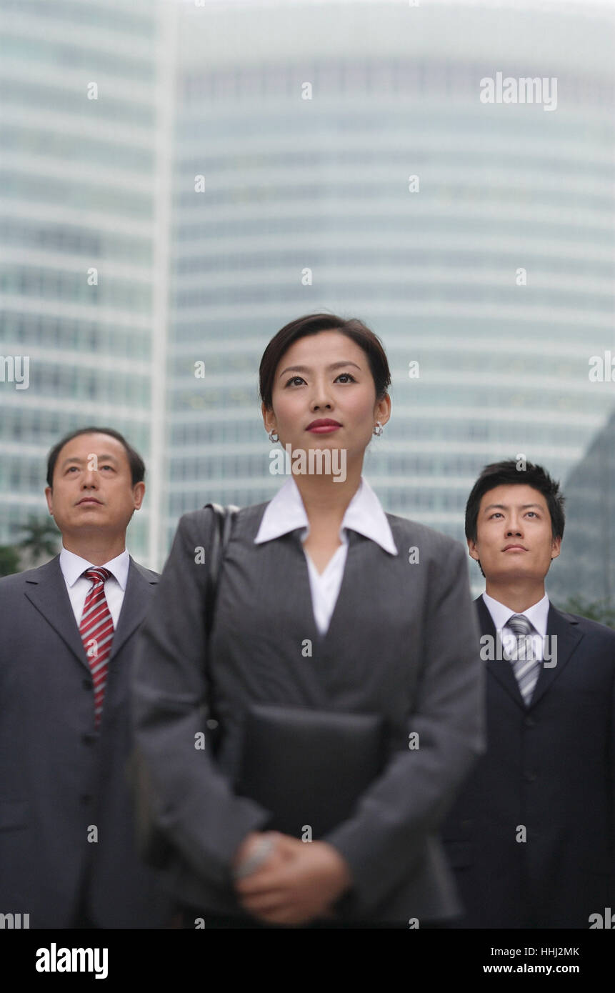 Three business professionals stand in front of a skyscraper Stock Photo ...