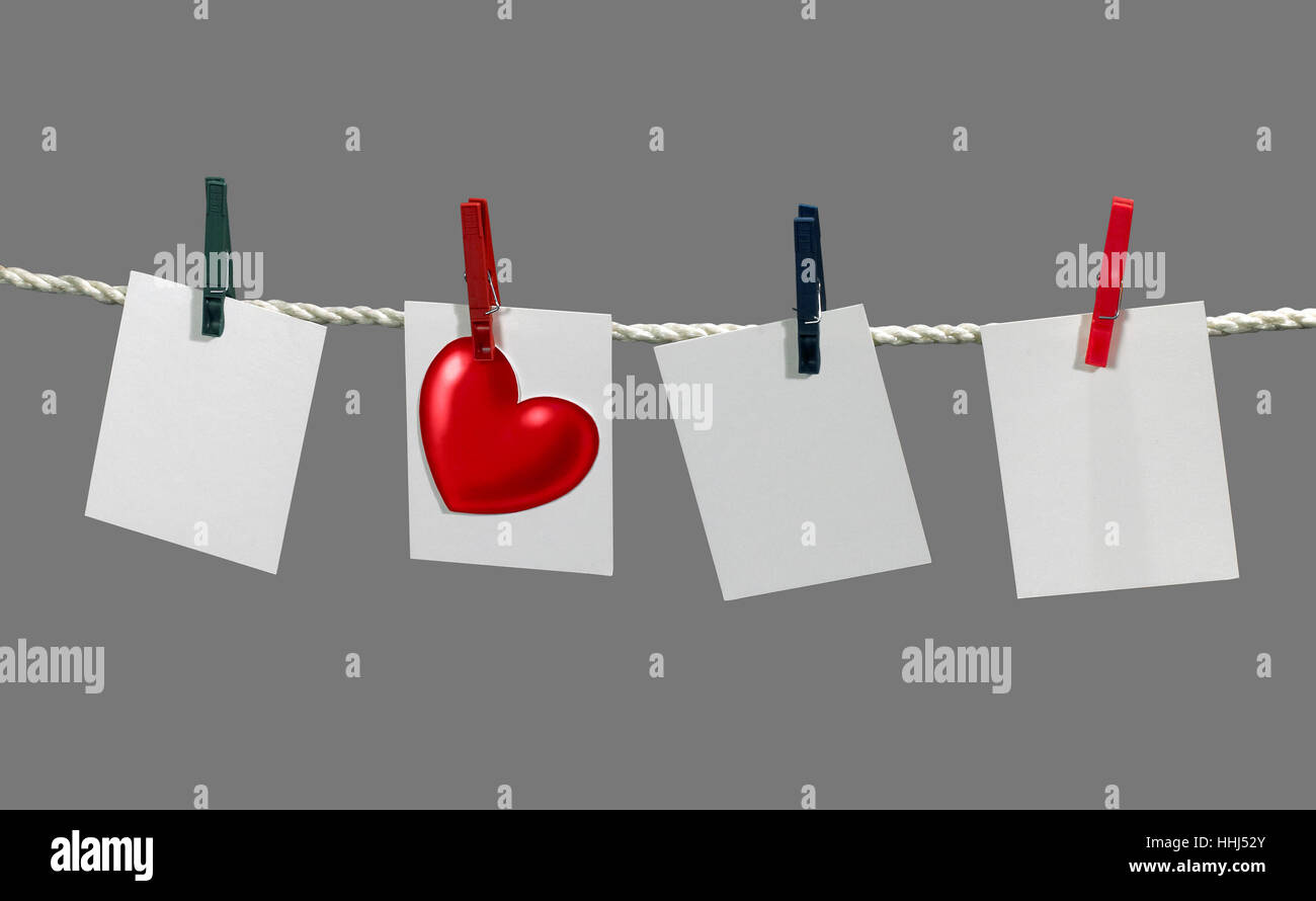 clothesline with some white labels and heart-shape fixed with clothes pins in grey back Stock Photo