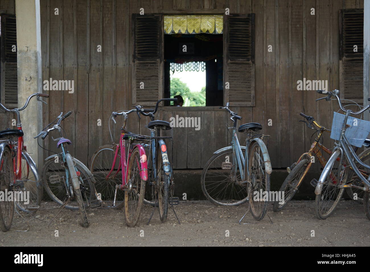 Bicycles Lined up Outside Wooden School with Wooden Shutters in Cambodia Asia Stock Photo