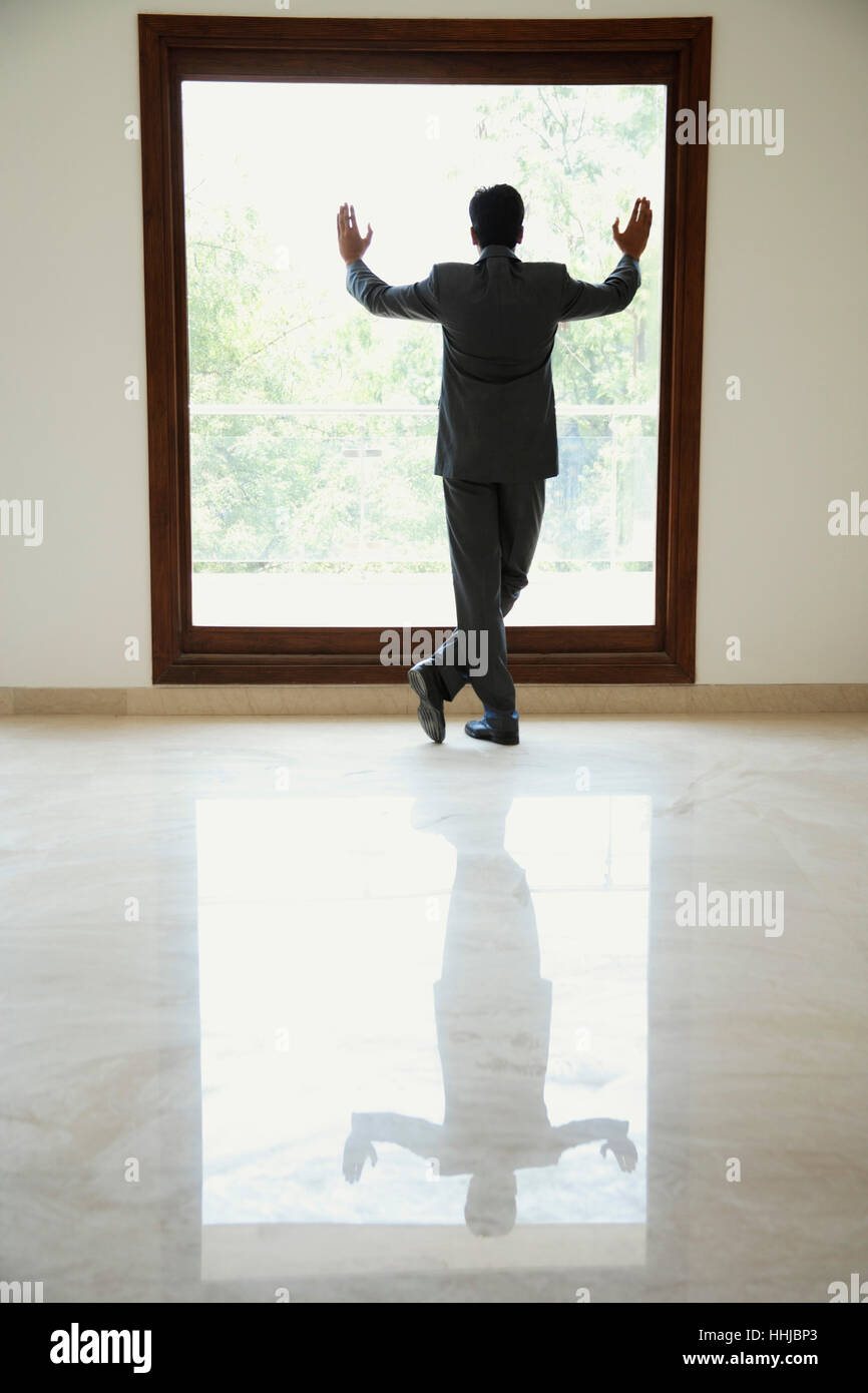 businessman standing with hands on window Stock Photo - Alamy