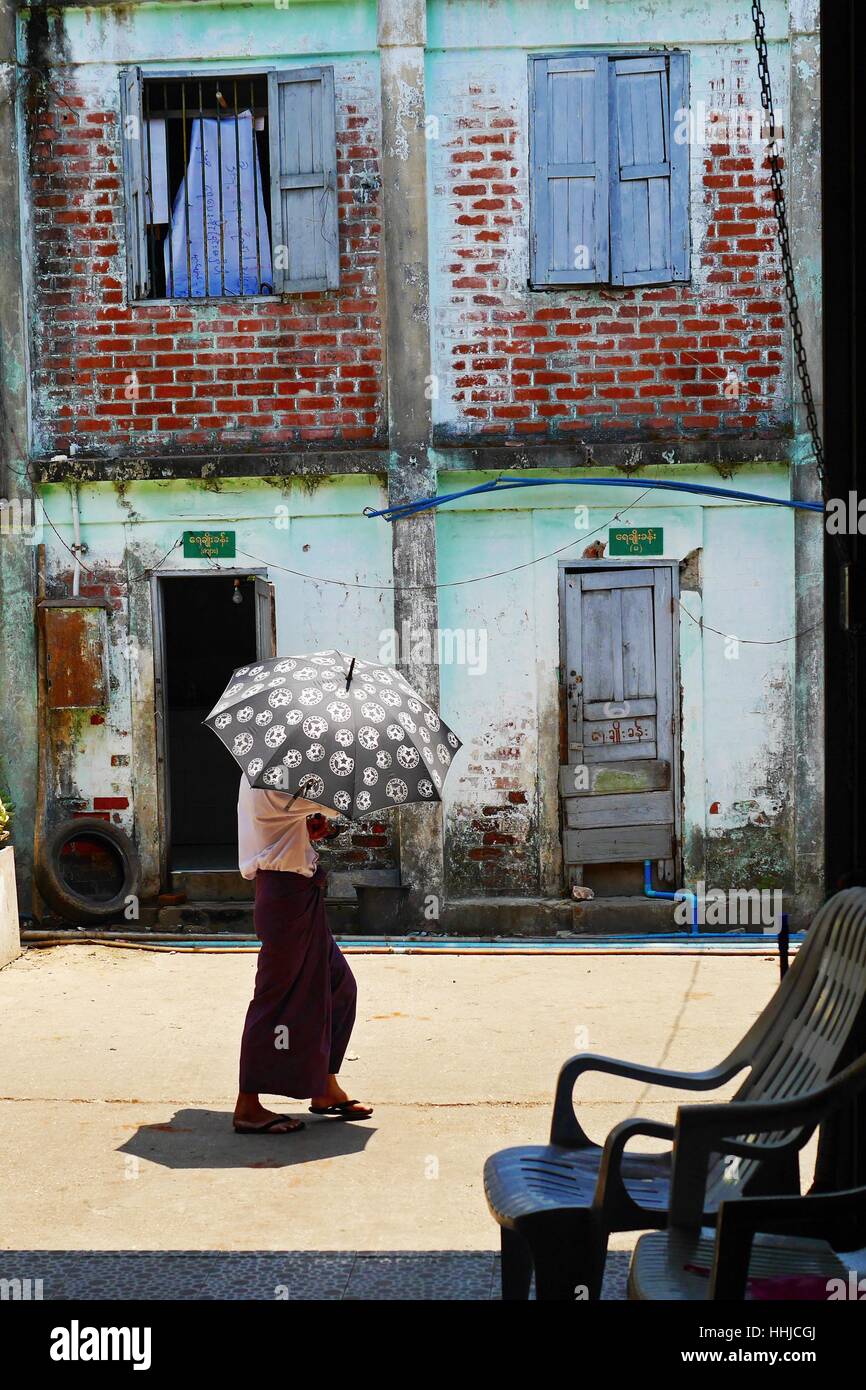 Burmese man walking along the street in Yangon, Myanmar. Stock Photo