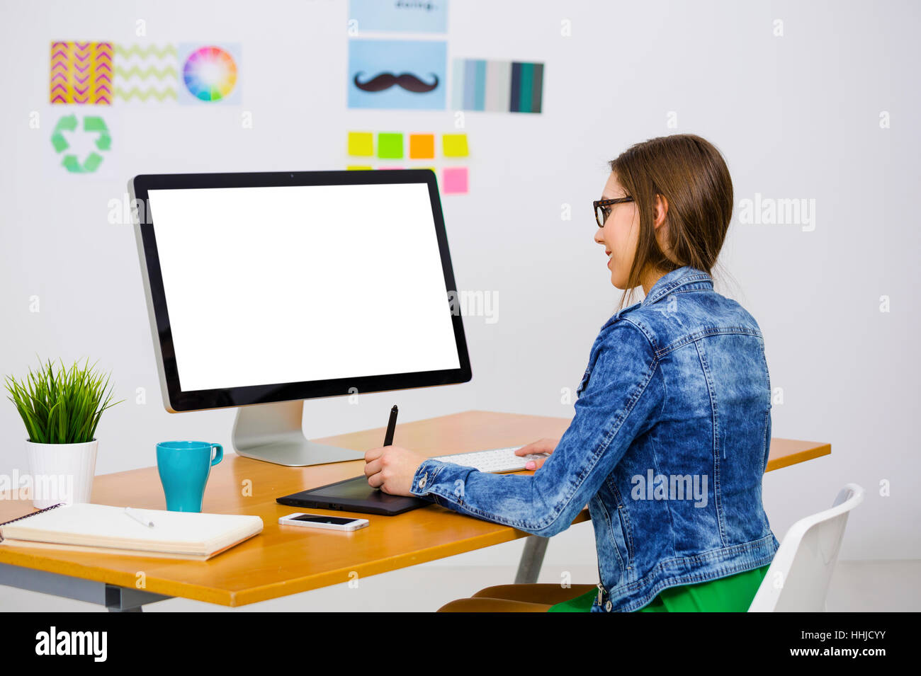 Woman working at desk In a creative office, using a computer Stock ...