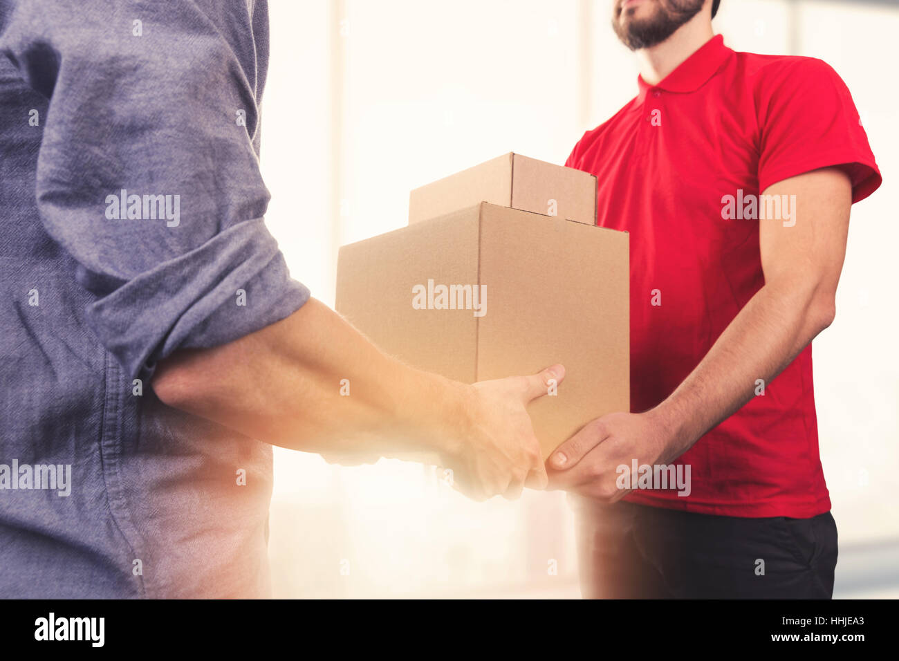 man accepting a delivery of boxes from delivery service courier Stock Photo