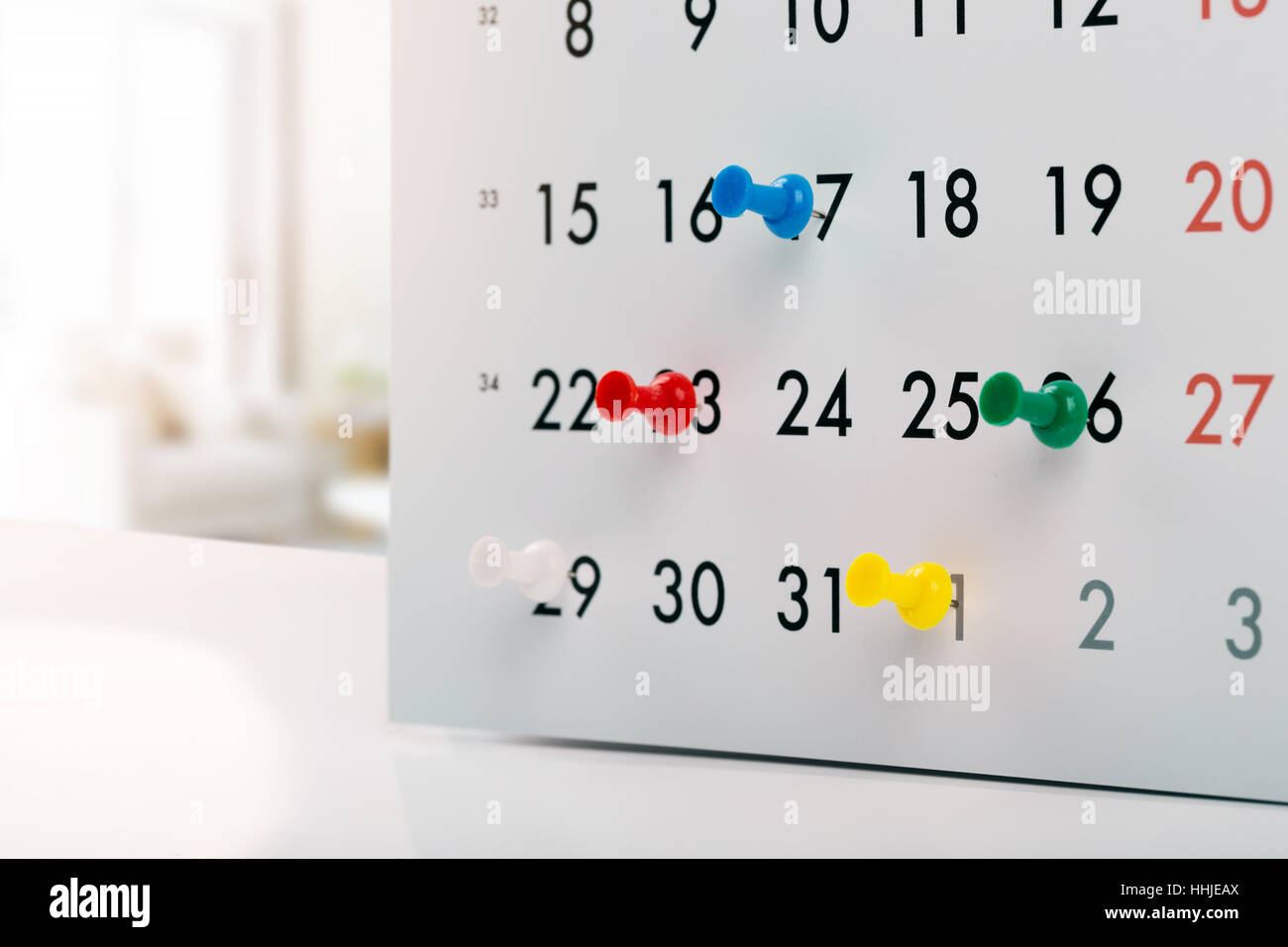 thumbtacks in calendar - concept of busy schedule Stock Photo