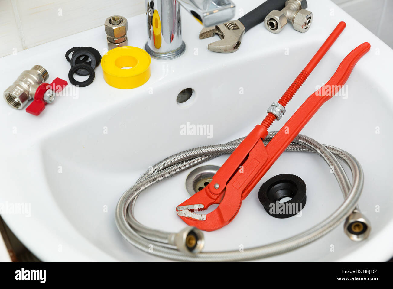 plumbing tools and equipment on sink in bathroom Stock Photo
