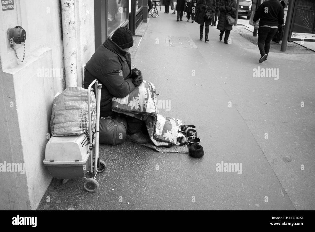 Homeless man begging for money with his cats, on streets in Paris Stock Photo