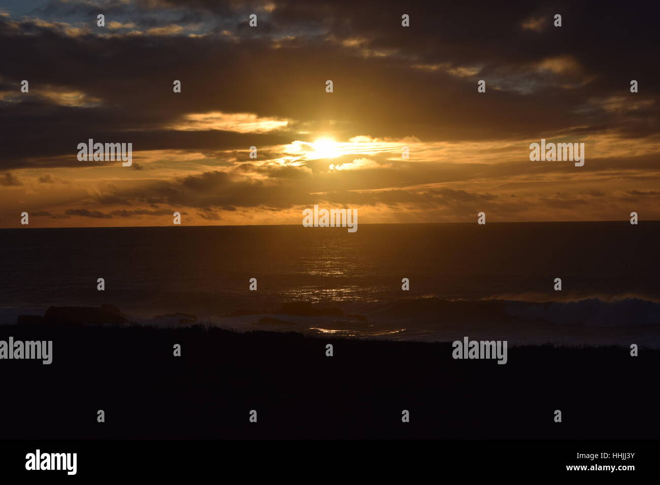 A cloudy golden sunset shimmers on the waves of the Pacific Ocean Stock ...